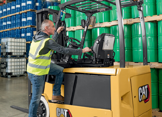 Worker climbing onto Cat cushion tire lift truck